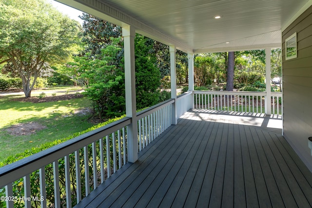 wooden terrace featuring covered porch and a yard