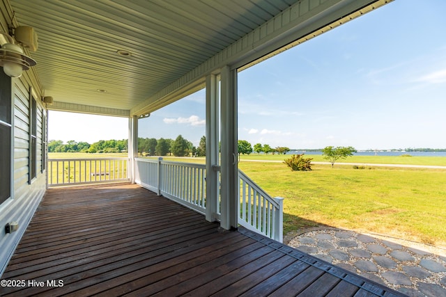 wooden deck with a lawn and a water view