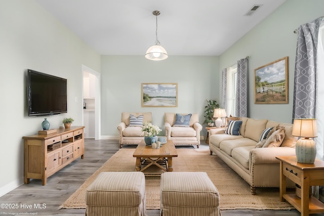 living area featuring baseboards, visible vents, and light wood-style floors