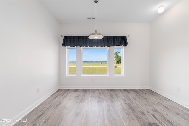 unfurnished dining area with baseboards, wood finished floors, and visible vents