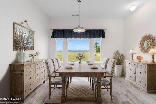 dining room featuring light wood-style flooring and visible vents