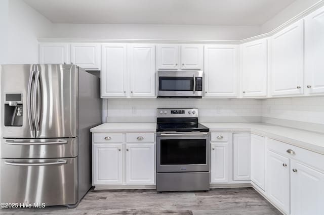 kitchen featuring light countertops, white cabinetry, backsplash, and stainless steel appliances