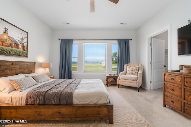 bedroom with a ceiling fan, light colored carpet, and visible vents