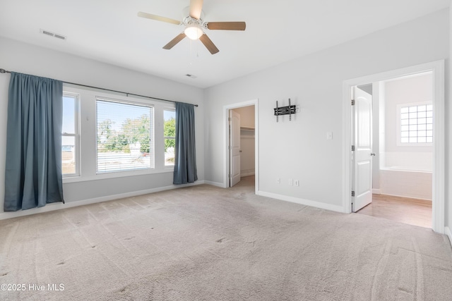 unfurnished bedroom featuring baseboards, multiple windows, and visible vents