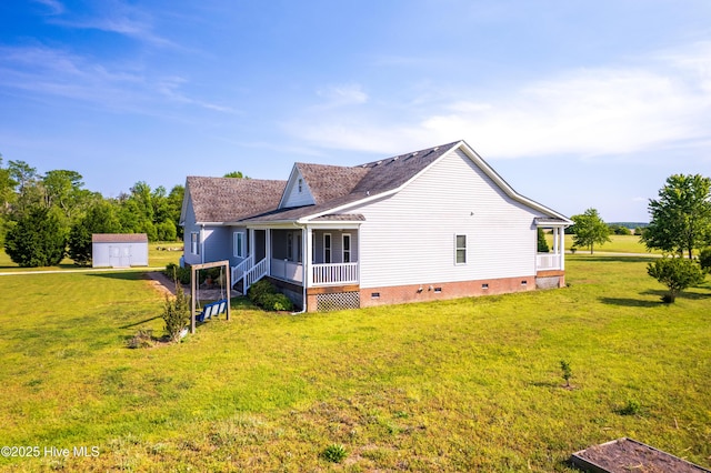 view of side of property with an outdoor structure, a lawn, a storage unit, crawl space, and a porch
