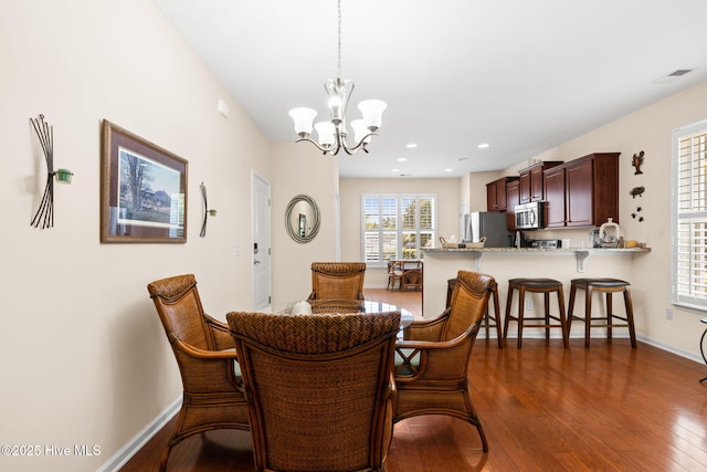 dining room featuring dark wood-type flooring, a chandelier, baseboards, and recessed lighting