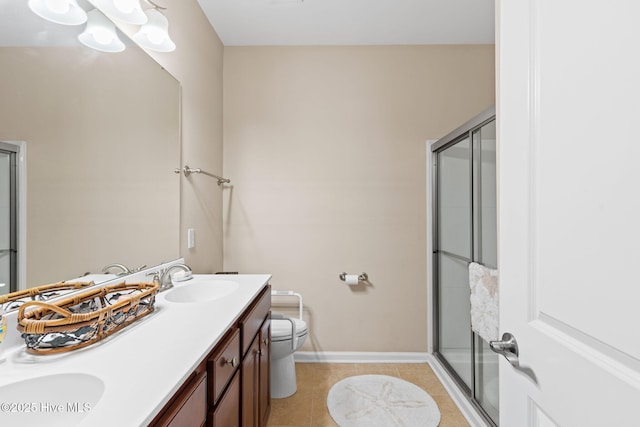 bathroom featuring an enclosed shower, baseboards, tile patterned floors, double vanity, and toilet