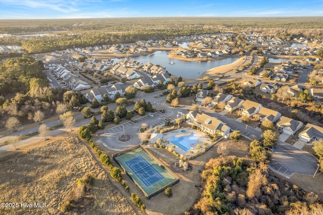 aerial view of property and surrounding area with a nearby body of water and nearby suburban area