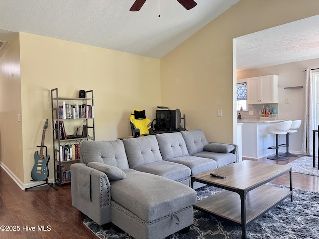 212 Red Carnation Dr, Holly Ridge, NC 28445 - living area with dark wood-type flooring, ceiling fan, vaulted ceiling, a textured ceiling, and baseboards