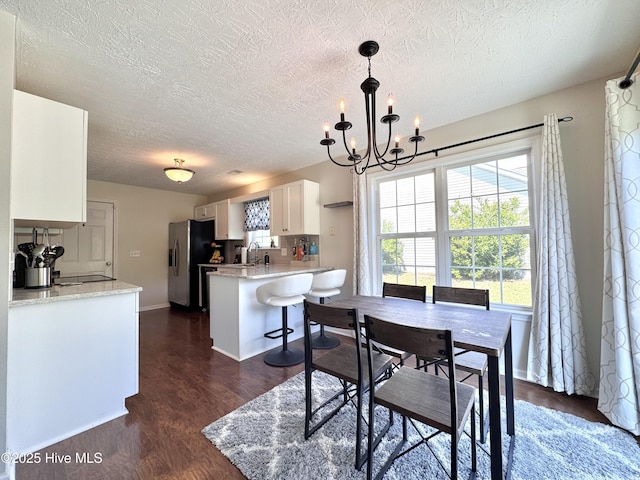 212 Red Carnation Dr, Holly Ridge, NC 28445 - dining room featuring a textured ceiling, dark wood-style floors, a chandelier, and baseboards