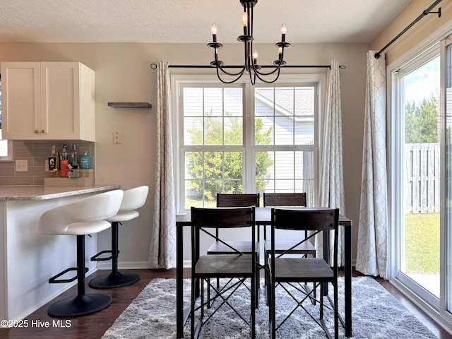 212 Red Carnation Dr, Holly Ridge, NC 28445 - dining space featuring a chandelier, baseboards, dark wood-style flooring, and a textured ceiling