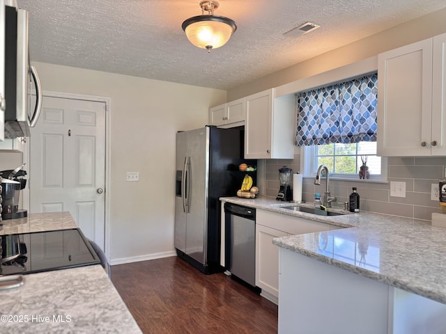 212 Red Carnation Dr, Holly Ridge, NC 28445 - kitchen with a sink, stainless steel appliances, dark wood finished floors, white cabinetry, and backsplash