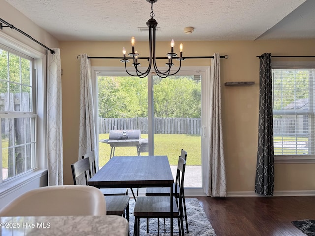 212 Red Carnation Dr, Holly Ridge, NC 28445 - dining area with a chandelier, dark wood-style flooring, a textured ceiling, and baseboards