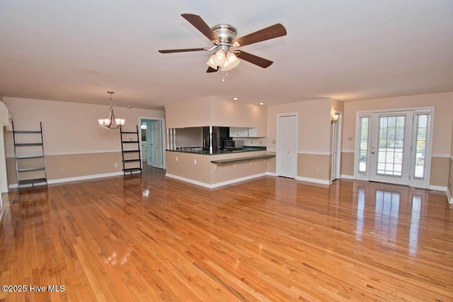104 Stevens Ct, Swansboro, NC 28584 - unfurnished living room with baseboards, light wood-style flooring, and ceiling fan with notable chandelier