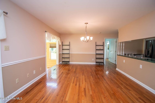 104 Stevens Ct, Swansboro, NC 28584 - unfurnished dining area with light wood-type flooring, a sink, baseboards, and a chandelier