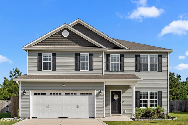 view of front of house with concrete driveway, an attached garage, and fence