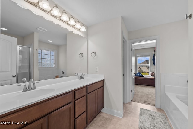 bathroom with a sink, visible vents, a shower stall, double vanity, and a garden tub