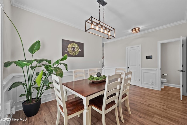 dining space with crown molding and a decorative wall