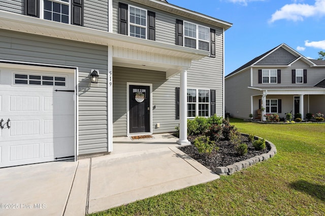 entrance to property with a lawn, a porch, and a garage