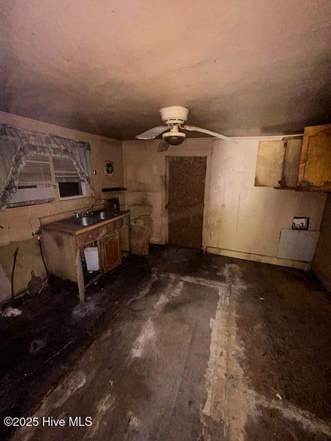 unfurnished living room with a ceiling fan and a sink