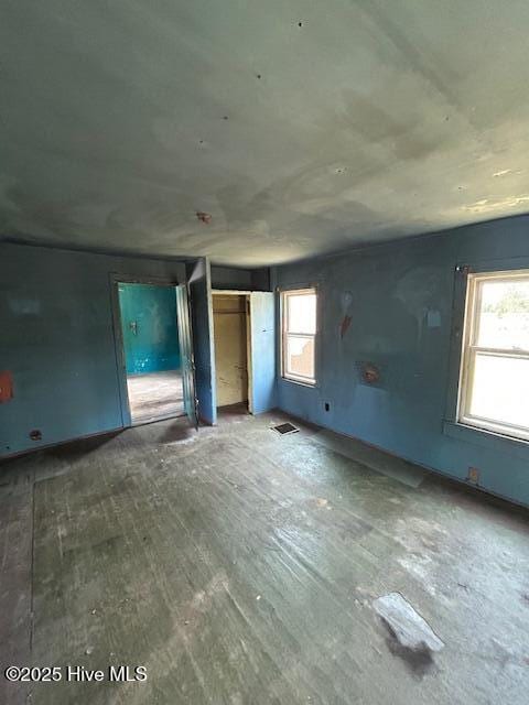 unfurnished bedroom featuring multiple windows and wood finished floors