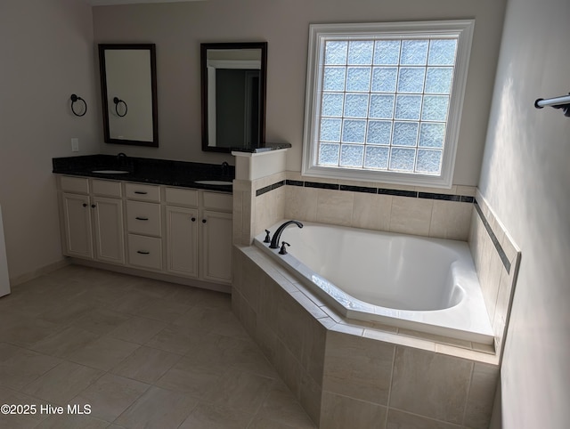 bathroom with a sink, a bath, and double vanity