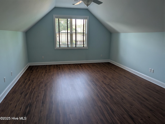 additional living space with baseboards, a ceiling fan, dark wood finished floors, and lofted ceiling