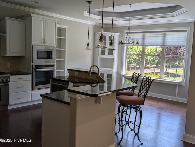 kitchen featuring dark wood-style flooring, dark countertops, appliances with stainless steel finishes, a sink, and ornamental molding