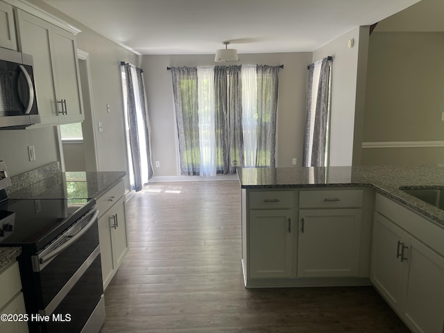 kitchen featuring stone countertops, dark wood finished floors, white cabinetry, and stainless steel appliances