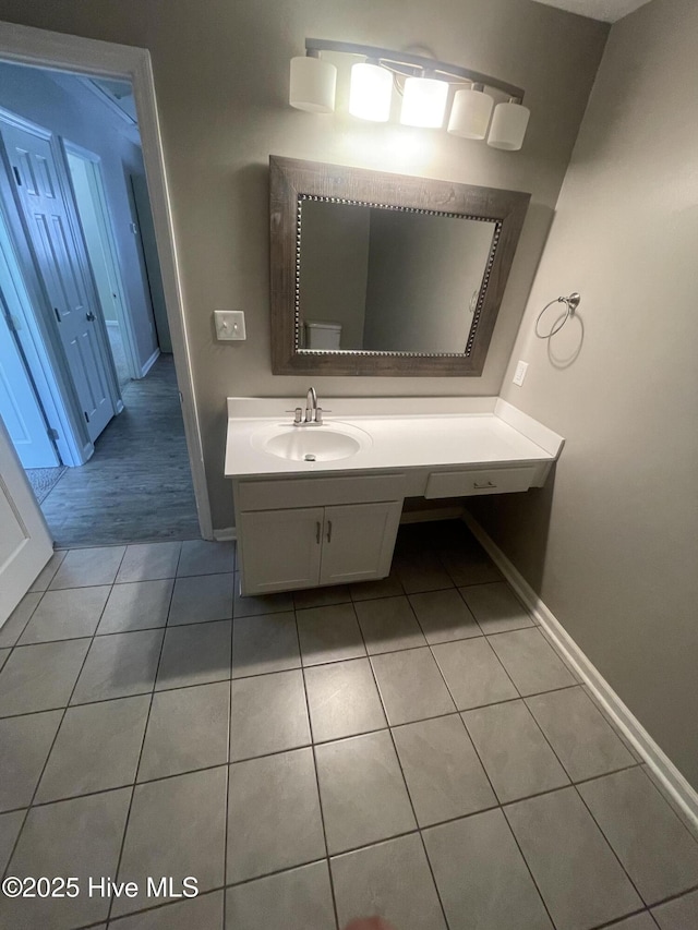 bathroom featuring baseboards, tile patterned flooring, and vanity