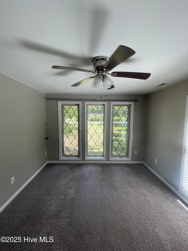 carpeted empty room featuring a ceiling fan and baseboards