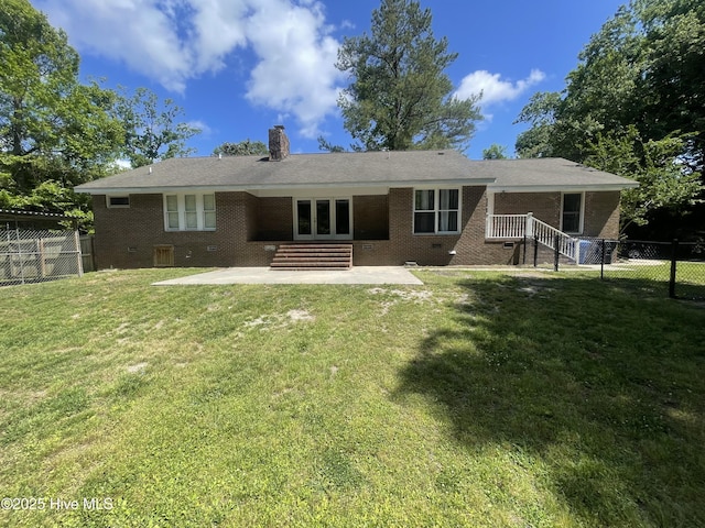 back of house featuring brick siding, a fenced backyard, a chimney, french doors, and a patio