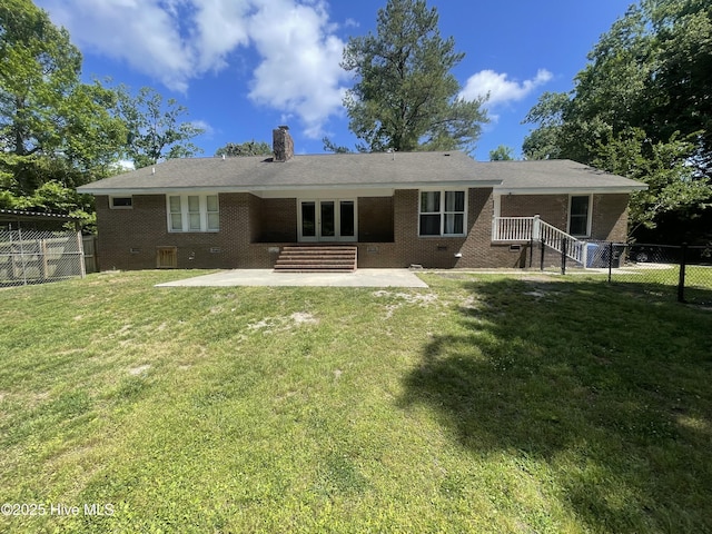rear view of property featuring fence, a patio, a chimney, and brick siding