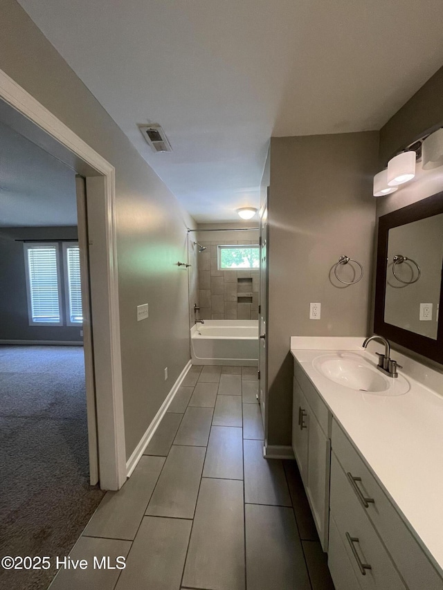 full bath with visible vents, tile patterned flooring, vanity, baseboards, and shower / tub combination
