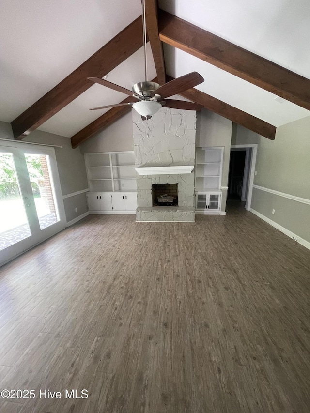 unfurnished living room with a ceiling fan, a fireplace, wood finished floors, baseboards, and vaulted ceiling with beams