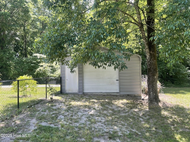detached garage with fence and a shed