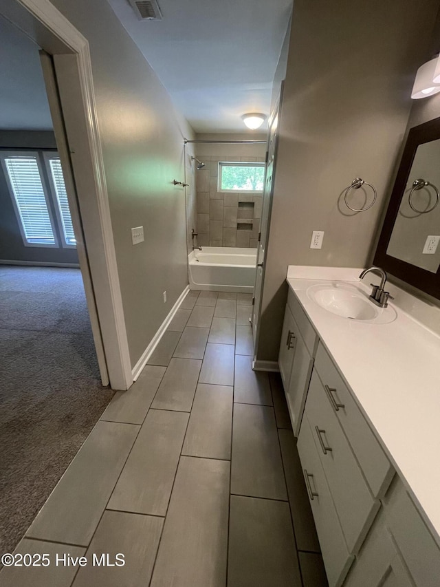 bathroom featuring visible vents, tile patterned flooring, baseboards, vanity, and shower / bathtub combination