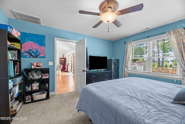 carpeted bedroom with ceiling fan and visible vents
