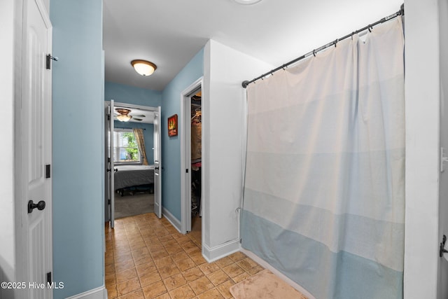 full bathroom with a ceiling fan, baseboards, and curtained shower