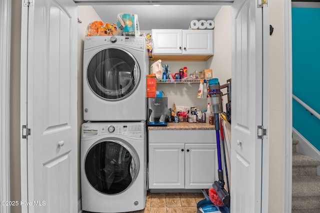 laundry area with stacked washer and dryer and cabinet space