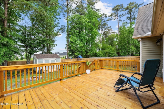 deck featuring a fenced backyard, a storage unit, an outbuilding, and a playground
