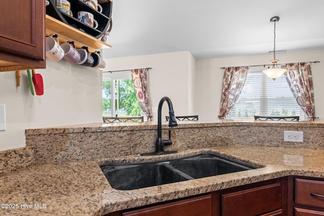 kitchen with a sink and light stone countertops