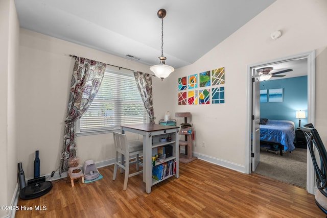 dining room featuring baseboards, lofted ceiling, wood finished floors, and visible vents