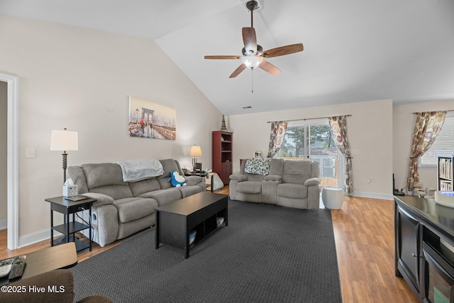 living area featuring light wood-type flooring, baseboards, ceiling fan, and vaulted ceiling