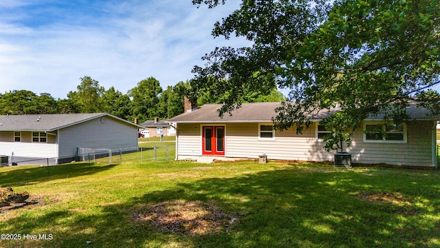 2 Cherokee Dr, Hubert, NC 28539 - rear view of house with central AC unit, fence, a yard, and a chimney
