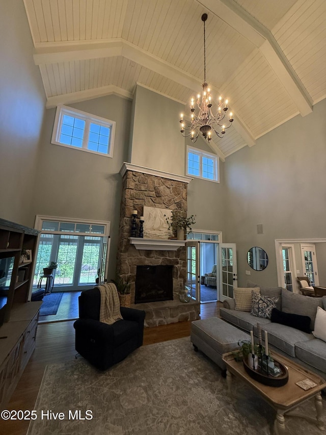 living area with a fireplace, high vaulted ceiling, a chandelier, wooden ceiling, and wood finished floors