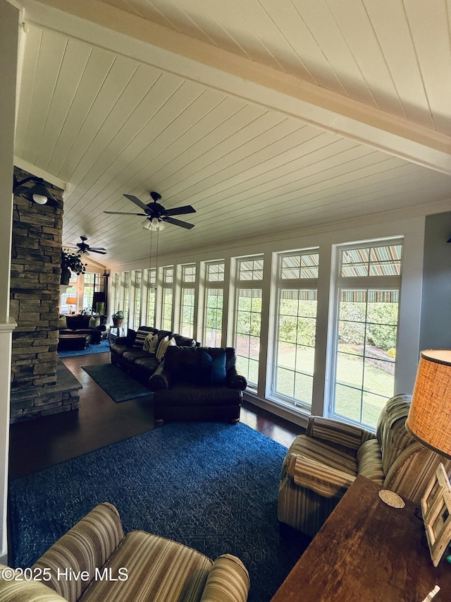 living room with ceiling fan, wood finished floors, a healthy amount of sunlight, and beamed ceiling