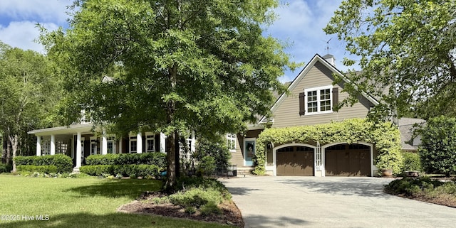 view of community featuring a lawn, driveway, and a garage