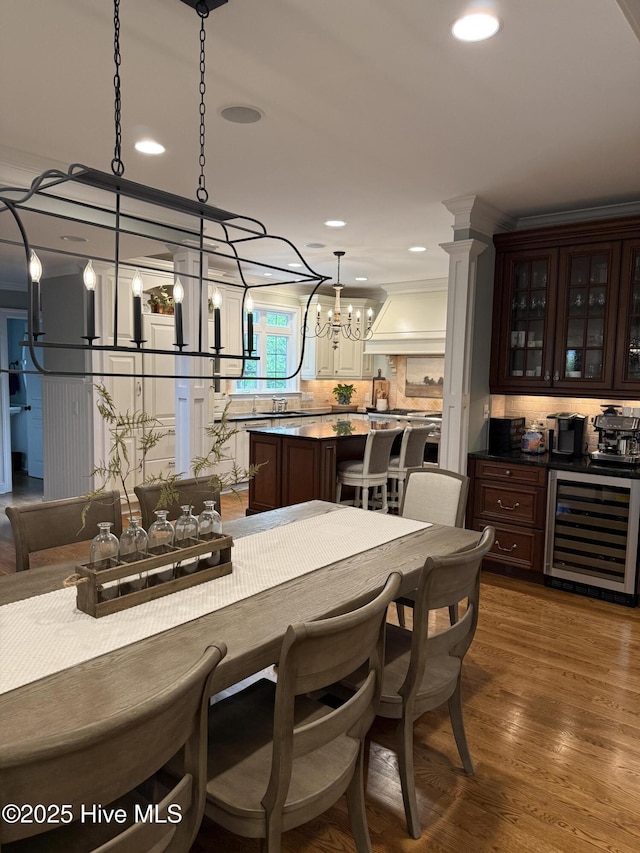 dining room with recessed lighting, a notable chandelier, dark wood-type flooring, and wine cooler