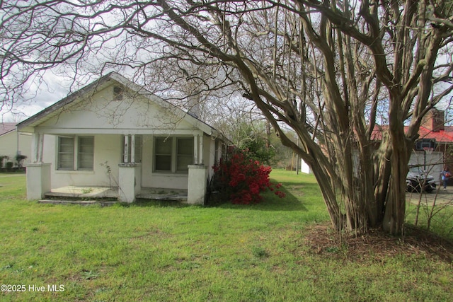 bungalow featuring a porch, stucco siding, and a front lawn